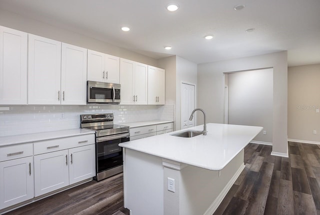 kitchen featuring stainless steel appliances, sink, white cabinets, and a kitchen island with sink