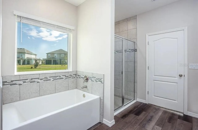 bathroom with hardwood / wood-style flooring and shower with separate bathtub