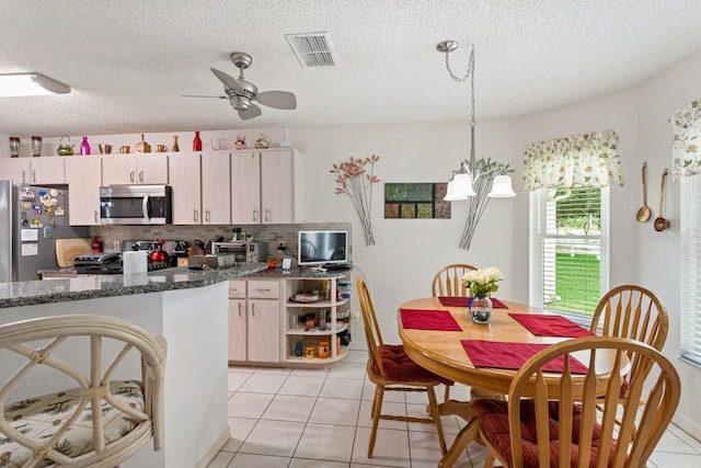 kitchen with ceiling fan, tasteful backsplash, light tile flooring, and appliances with stainless steel finishes