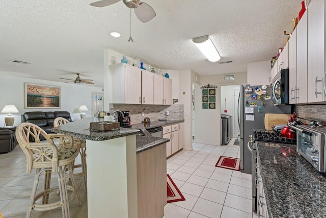 kitchen with tasteful backsplash, ceiling fan, and kitchen peninsula