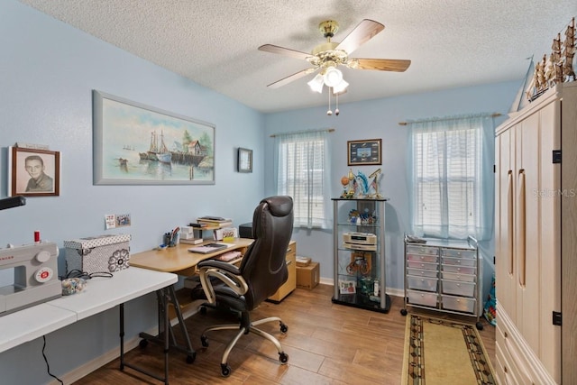 office area featuring light hardwood / wood-style floors, a textured ceiling, and ceiling fan