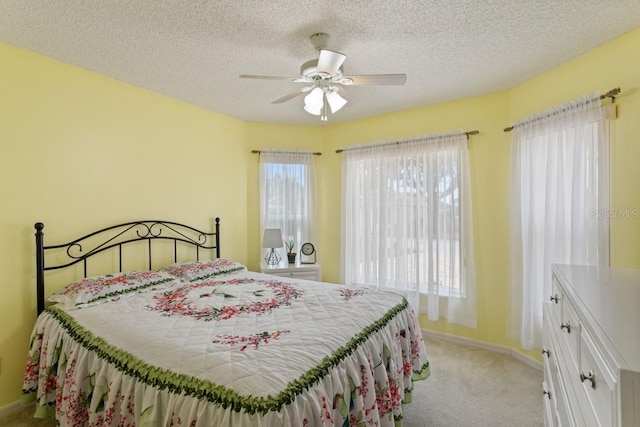 bedroom with light carpet, a textured ceiling, and ceiling fan