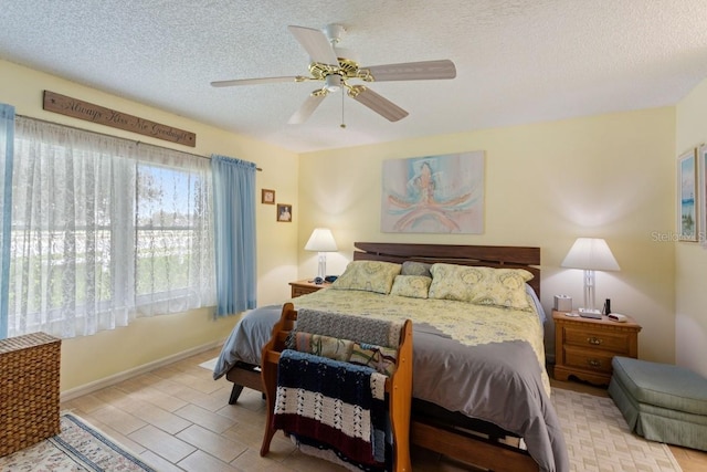 bedroom featuring ceiling fan and a textured ceiling