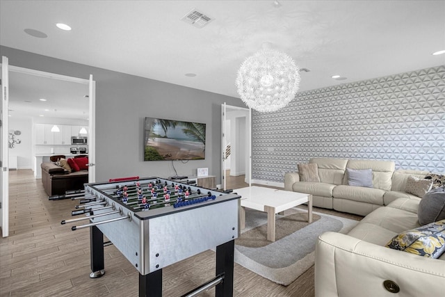 playroom featuring hardwood / wood-style floors and a notable chandelier