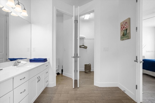 bathroom featuring vanity, hardwood / wood-style floors, toilet, and an inviting chandelier