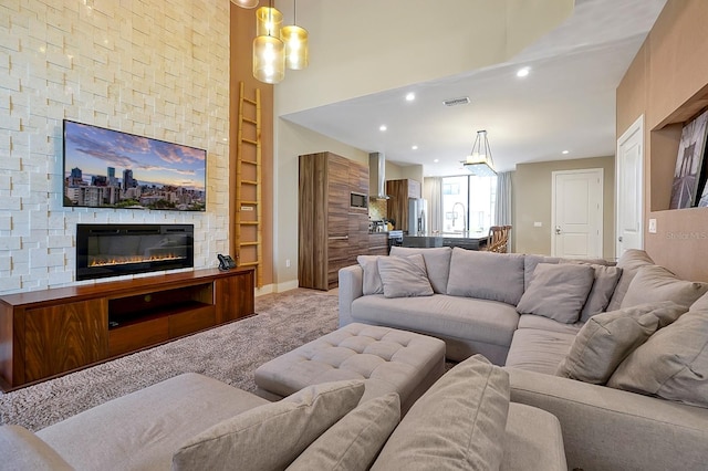 carpeted living room with a stone fireplace and built in shelves