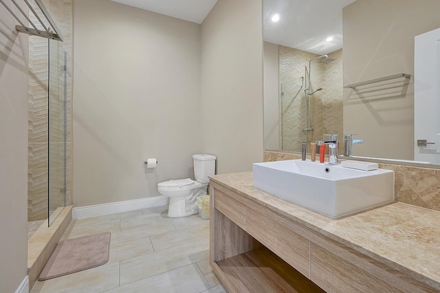 bathroom featuring toilet, a shower with door, tile floors, and vanity