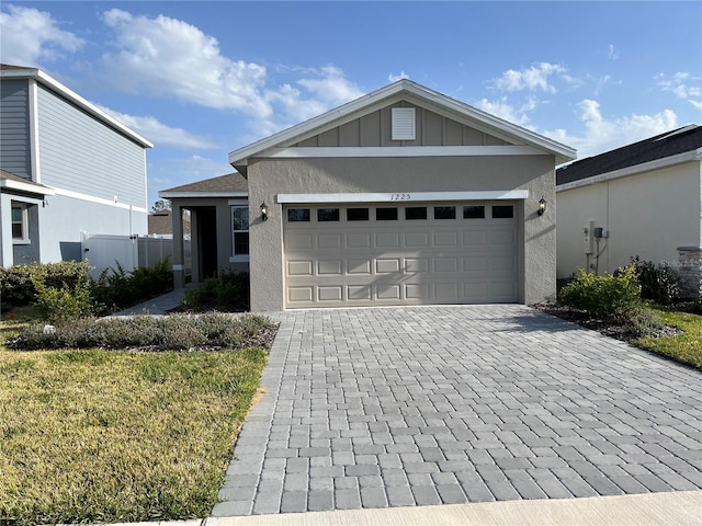 single story home featuring stucco siding, an attached garage, decorative driveway, and board and batten siding