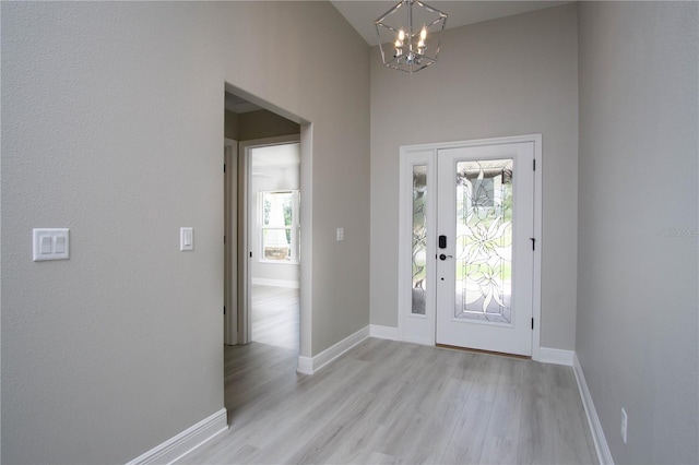 entryway with light hardwood / wood-style floors and a notable chandelier