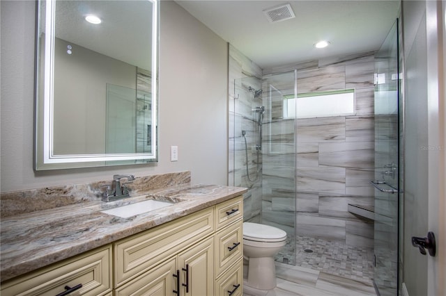 bathroom with toilet, tile floors, an enclosed shower, and vanity