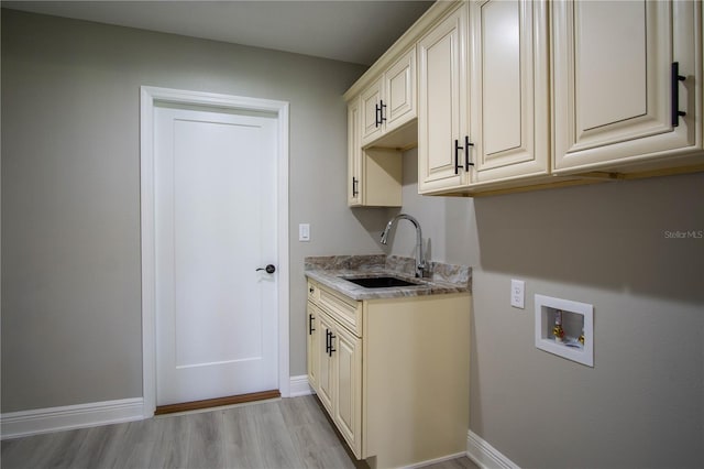 clothes washing area with cabinets, hookup for a washing machine, sink, and light wood-type flooring