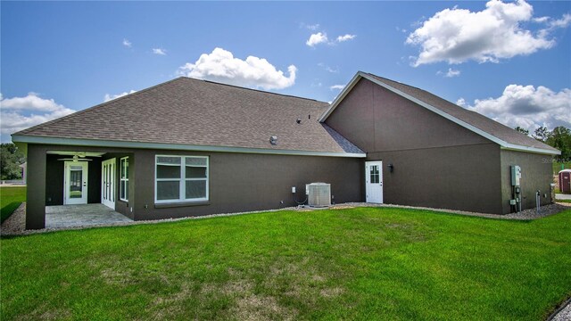 rear view of house with central AC, ceiling fan, a lawn, and a patio