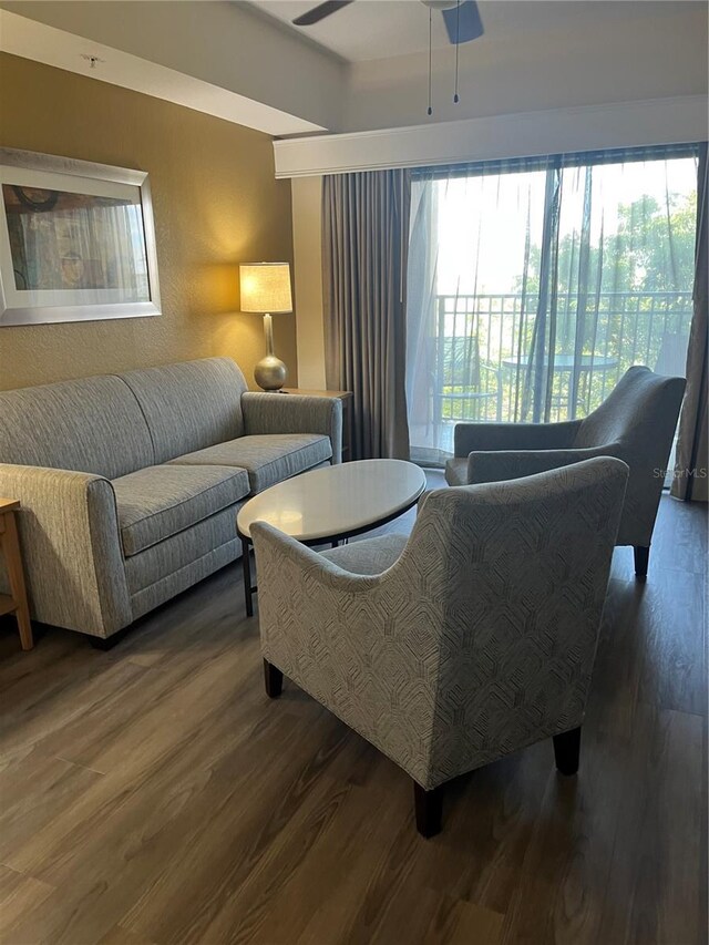 living area featuring ceiling fan and dark wood-style flooring