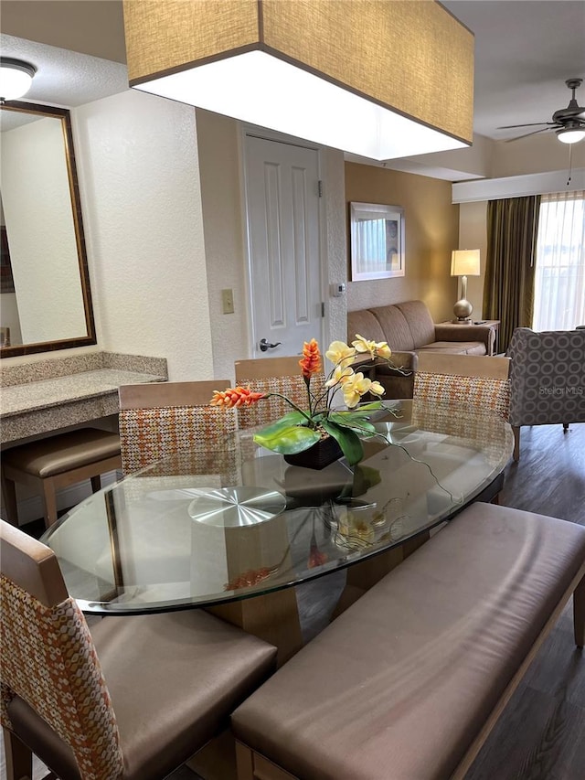 dining space with ceiling fan and wood finished floors