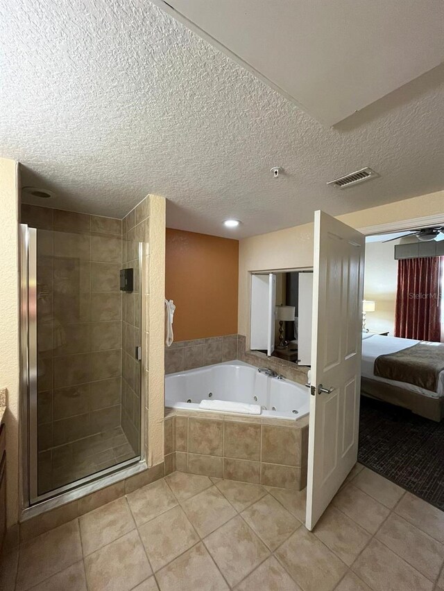 full bathroom featuring visible vents, a tub with jets, tile patterned floors, a textured ceiling, and a shower stall