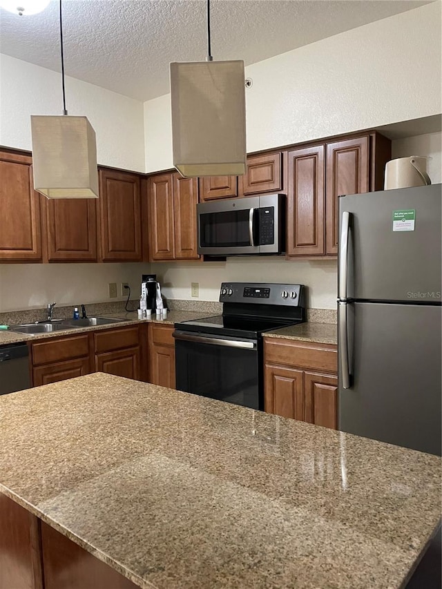 12521 Floridays Resort Dr Unit 302F, Orlando, FL 32821 - kitchen with black appliances, a sink, a textured ceiling, decorative light fixtures, and brown cabinetry