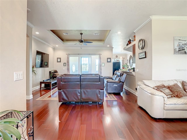 living room featuring crown molding, wood-type flooring, ceiling fan, and a raised ceiling