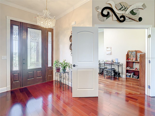 foyer entrance with an inviting chandelier, hardwood / wood-style floors, and ornamental molding