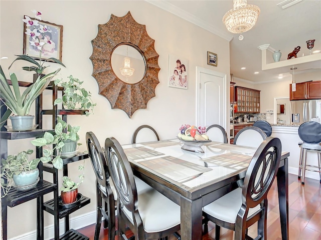 dining room featuring crown molding, hardwood / wood-style floors, and a chandelier