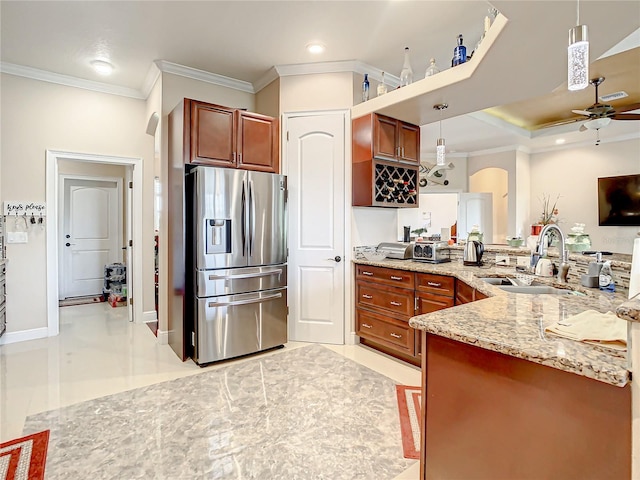 kitchen with ceiling fan, kitchen peninsula, stainless steel refrigerator with ice dispenser, hanging light fixtures, and sink