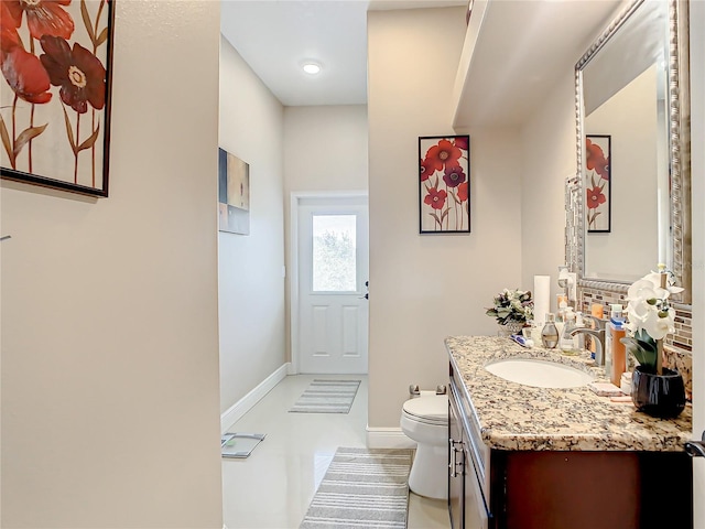 bathroom with tile flooring, vanity with extensive cabinet space, and toilet