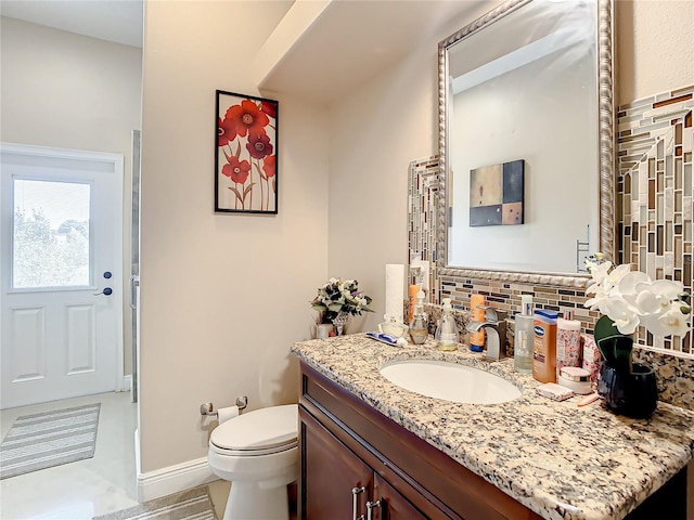 bathroom featuring tile floors, tasteful backsplash, vanity, and toilet