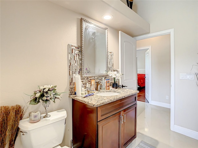 bathroom featuring oversized vanity, toilet, and tasteful backsplash