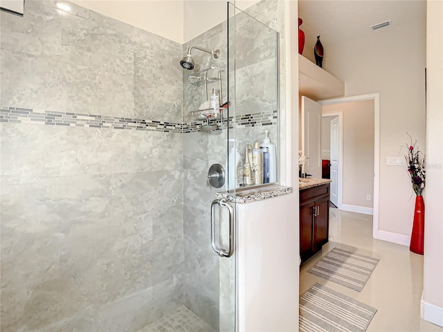 bathroom with a shower with door, tile flooring, and vanity