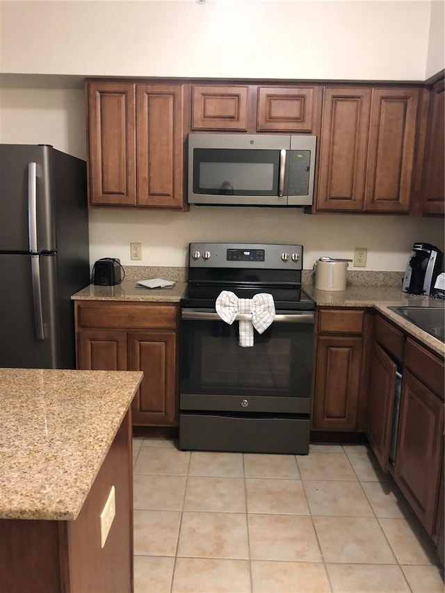 kitchen with sink, light tile patterned flooring, and appliances with stainless steel finishes