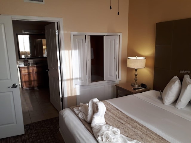 bedroom with a closet and dark tile patterned floors