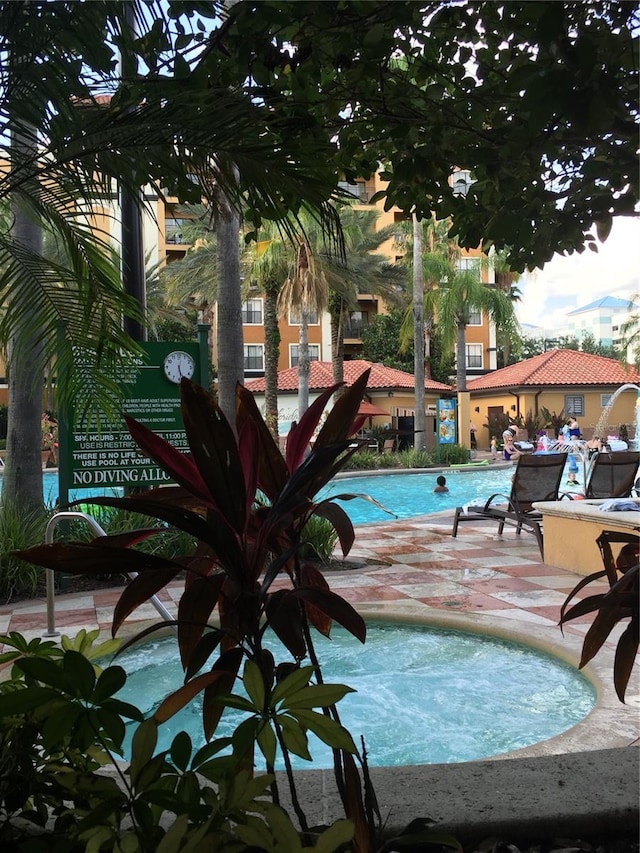 view of pool featuring a patio and a community hot tub