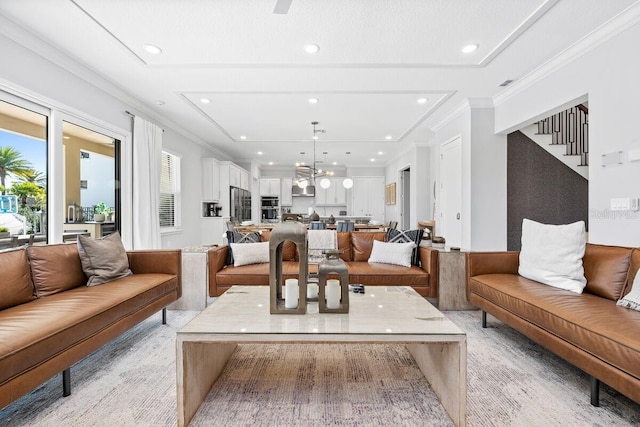 living room featuring a chandelier, a healthy amount of sunlight, and ornamental molding