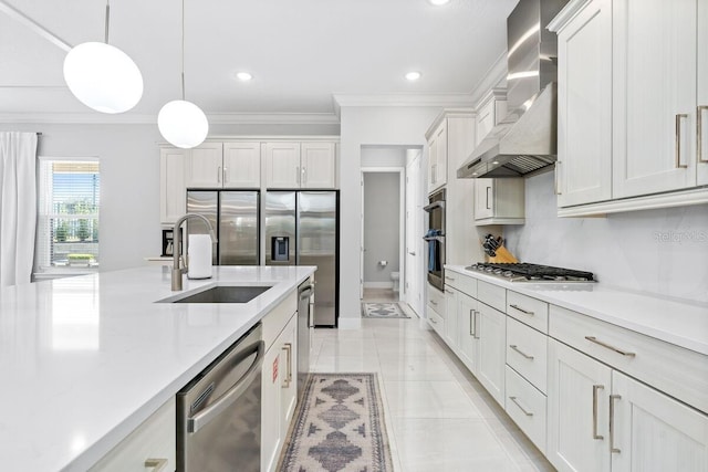 kitchen with hanging light fixtures, stainless steel appliances, light tile floors, white cabinets, and wall chimney range hood