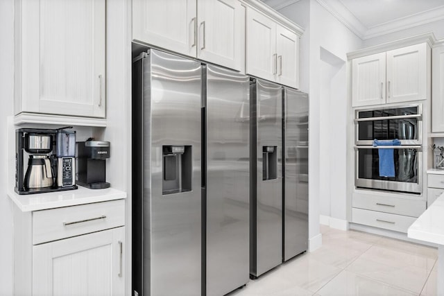 kitchen featuring stainless steel appliances, light tile floors, white cabinetry, and crown molding