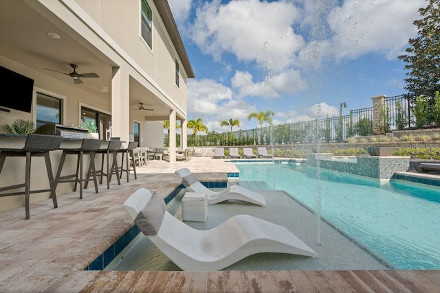 view of pool featuring an outdoor bar, ceiling fan, and a patio area