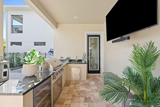 view of terrace featuring exterior kitchen, a grill, sink, and beverage cooler