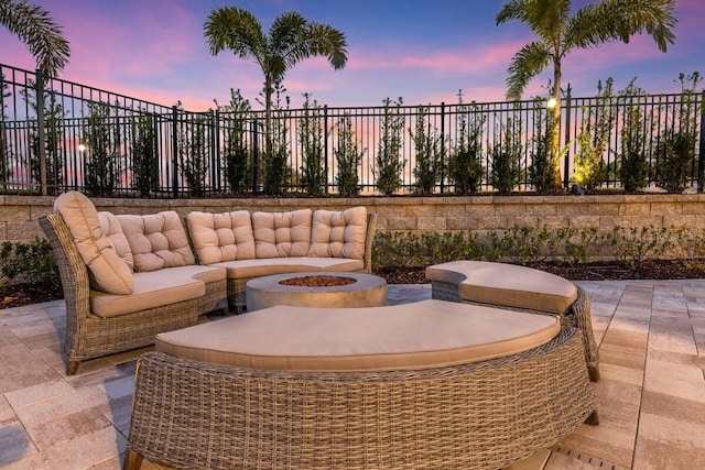 patio terrace at dusk with an outdoor living space with a fire pit