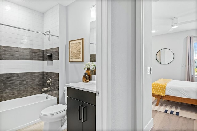 full bathroom featuring tiled shower / bath combo, vanity, ceiling fan, toilet, and hardwood / wood-style flooring