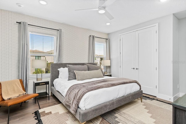 bedroom with multiple windows, ceiling fan, and light hardwood / wood-style flooring