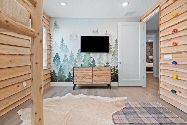 bedroom with a textured ceiling and light wood-type flooring