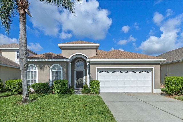 view of front of home with a front yard and a garage