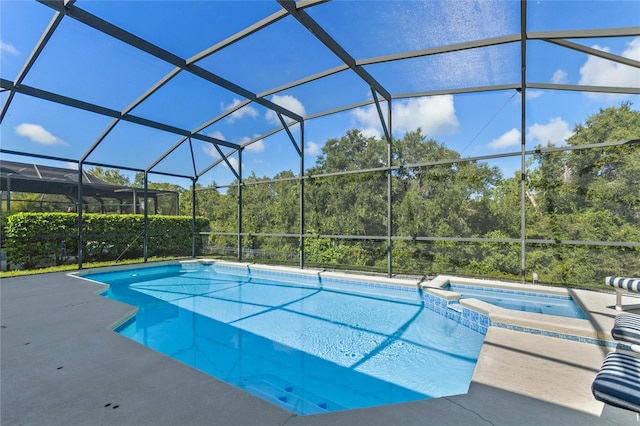 view of pool with an in ground hot tub, a lanai, and a patio