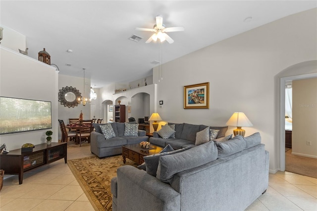 living room with light tile flooring and ceiling fan with notable chandelier