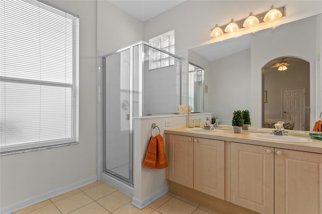 bathroom with double sink vanity, tile flooring, a shower with shower door, and ceiling fan