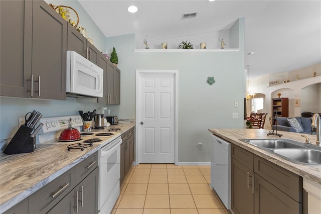 kitchen featuring light tile flooring, vaulted ceiling, white appliances, gray cabinetry, and sink