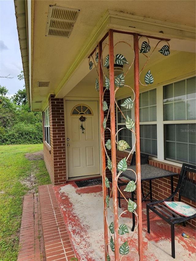 doorway to property with a lawn