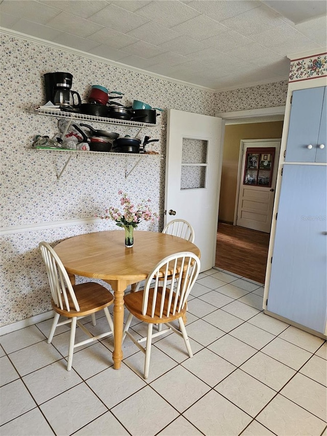 dining space with ornamental molding and light tile flooring