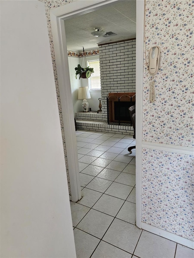 corridor featuring light tile floors and a textured ceiling