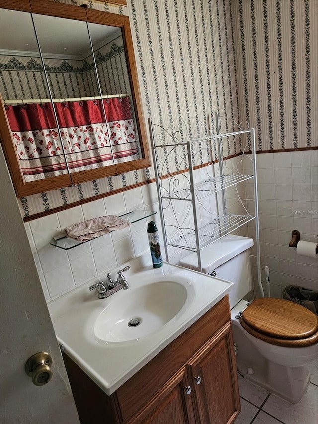 bathroom with tile walls, toilet, vanity, and tile floors