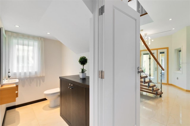 bathroom with a notable chandelier, toilet, and vanity